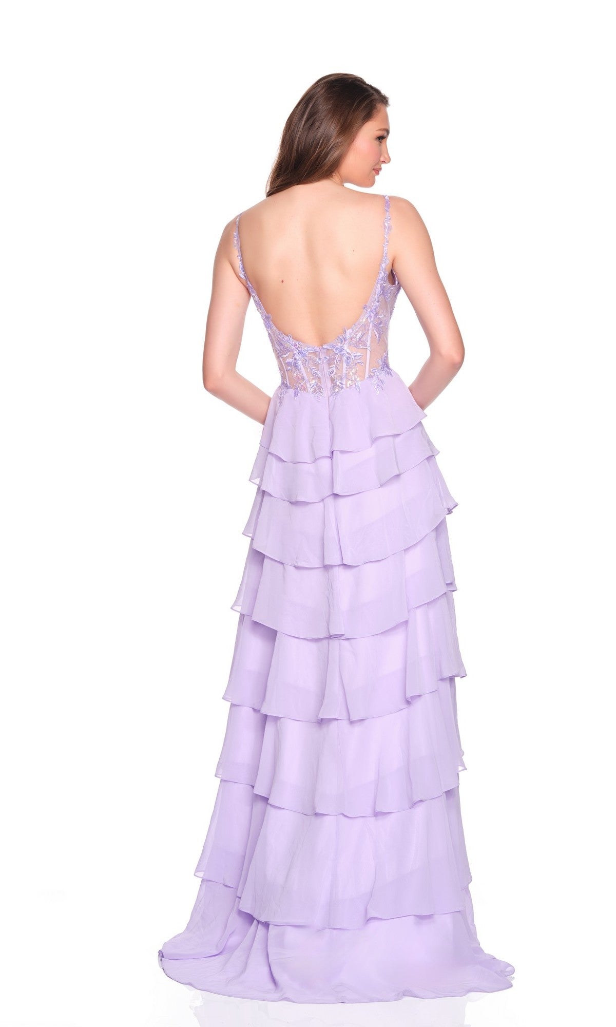 A woman wears the Dave and Johnny 12680 long prom dress, featuring a light purple corset bodice, thin straps, low back, and tiered ruffle chiffon A-line skirt, standing against a white background.
